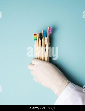 multicolored wooden toothbrushes on a blue background, plastic rejection concept, zero waste Stock Photo