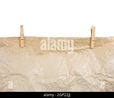 brown crumpled paper hanging on wooden clothespins, texture isolated on white background Stock Photo