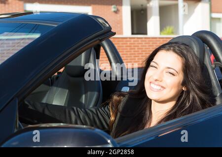 A young successful business woman in a luxurious convertible sports car Stock Photo