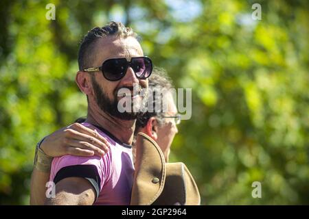 LOVINAC, CROATIA - Sep 25, 2021: Portrait of two happy young man embraced walking in a park Stock Photo
