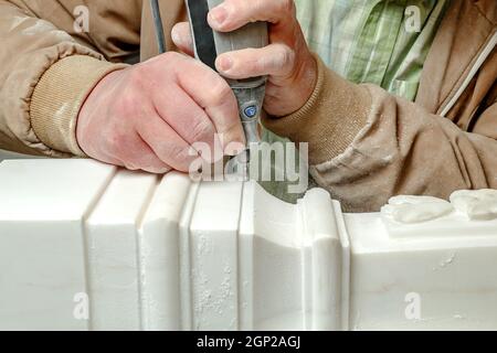 Hands stonecutter close up. Art processing of a stone. Small Drill for craft work Stock Photo