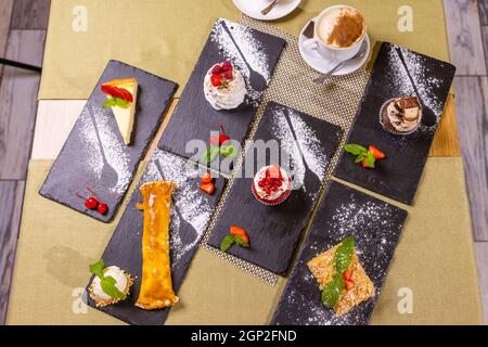 Assortment of confectionery, different types of cakes and desserts on the table Stock Photo