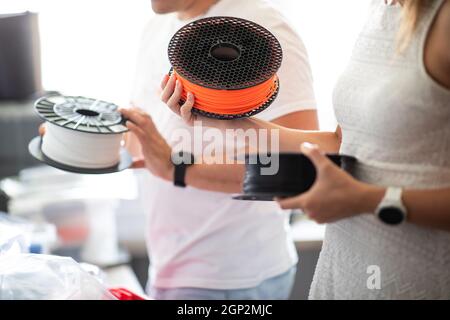 3D Printer Plastic filament for 3D printer and printed products in the hands of a young man Stock Photo
