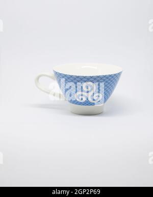 white and blue cup with a blue breton pattern on a white background. Stock Photo