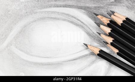panoramic view of set of black graphite pencils on hand-drawn academic drawing of cast eye close up Stock Photo