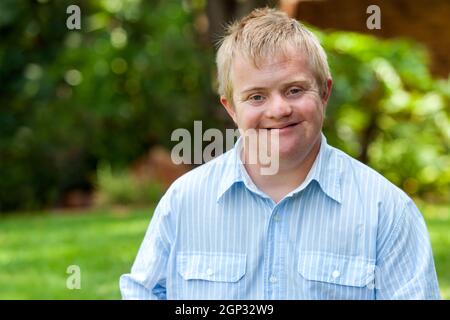 Portrait of handsome handicapped boy in blue shirt outdoors. Stock Photo