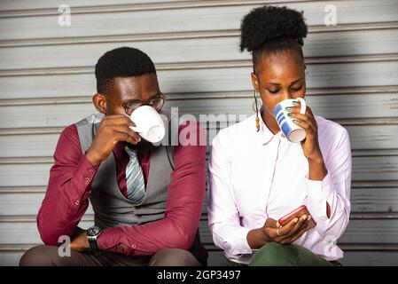young business people sitting outside and drinking a cup of coffee Stock Photo
