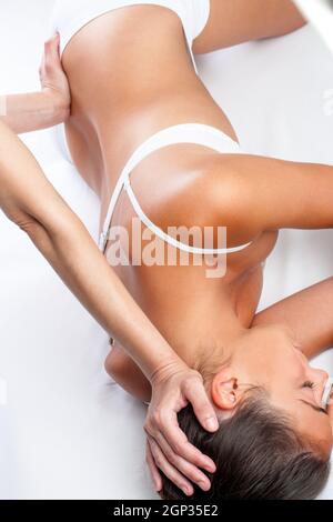 Top view of physiotherapist doing visceral spine treatment on woman. Stock Photo