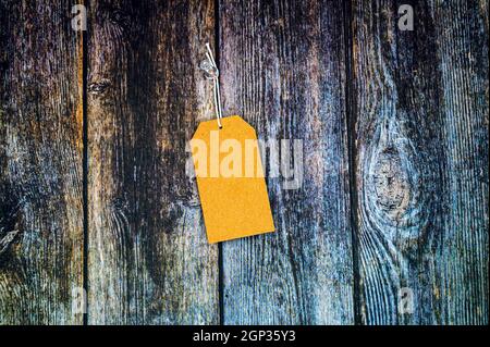 Blank gift label mockup with copy space pinned on a vintage wooden background. Stock Photo
