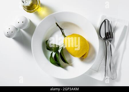 lemon on a plate. table setting. tableware. cutlery. on white Stock Photo