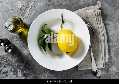 lemon on a plate. table setting. tableware. cutlery. on a dark background Stock Photo