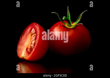 Washed red cherry tomatoes on a black background. Close-up view. Healthy eating concept Stock Photo