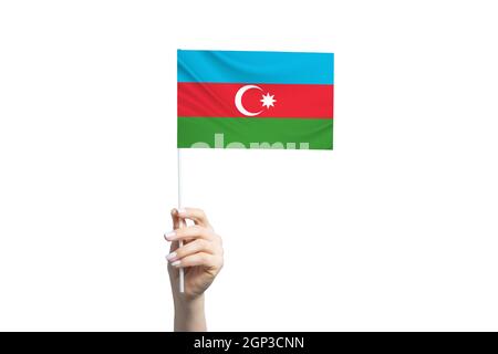 A beautiful female hand holds a Azerbaijan flag to which she shows the finger of her other hand, isolated on white background. Stock Photo