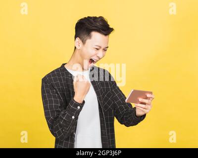 happy young man  reading  message on his smart phone  and celebrating victory Stock Photo
