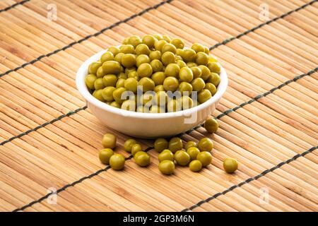 Canned green peas in the bowl on wood background Stock Photo