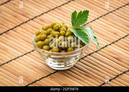 Canned green peas in the bowl on wood background Stock Photo