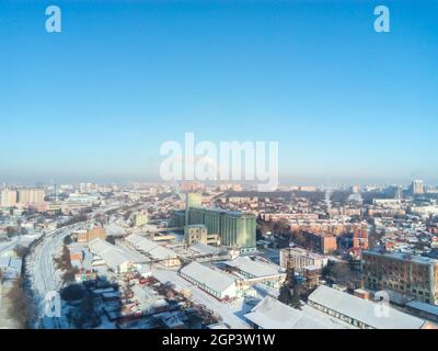Winter town. Frosty sunny day in the city. Snow on the streets and smoke from the boiler rises. Frost and sun, a wonderful day. Stock Photo