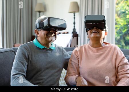 Two happy diverse senior couple wearing vr headset and having fun Stock Photo