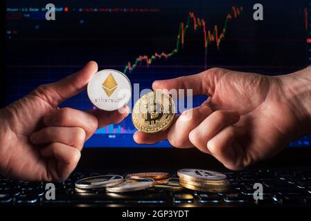 Business men holding bitcoin and ethereum coin whit computer trading chart background. Bitcoin and altcoin the most important cryptocurrency concept Stock Photo