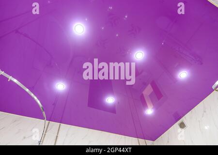 Stretch glossy ceiling of bright purple color in the bathroom Stock Photo