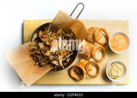 Beer snack: spicy chicken wings, cheese balls, fried black bread toast with garlic, onion rings in batter. Snack on a white background. Stock Photo