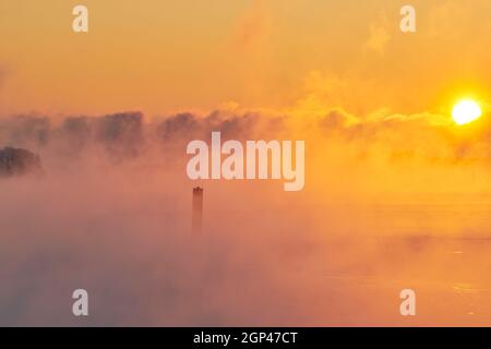 Almost completely frozen Baltic sea in extremely cold weather in Helsinki, Finland with thick sea smoke raising from the Baltic sea at sunrise in Janu Stock Photo