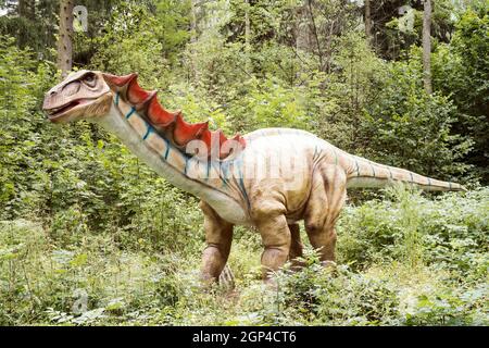 Gigantic statue of realistic dinosaur in a forest Stock Photo