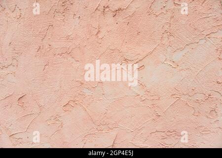 Detail of an exterior wall painted with a light pink embossed cladding. Background with copy space Stock Photo