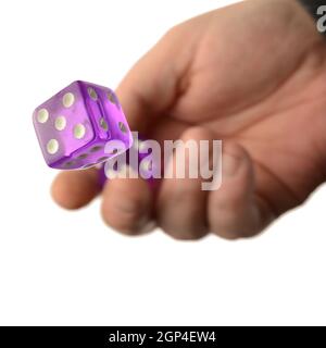 A concept of risk involvement with a hand and a roll of the dice over a white background. Stock Photo