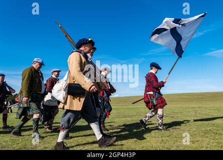 Jacobite Scotsmen in period costume march with saltire in re-enactment of Battle of Prestonpans , East Lothian, Scotland, UK Stock Photo