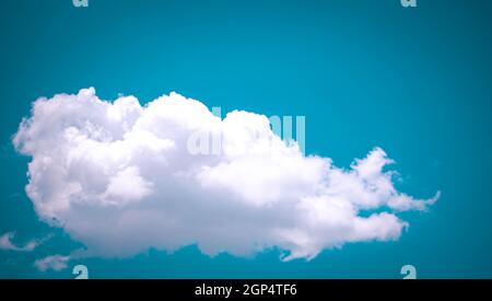 Heart shaped gate decorate with purple p A single fluffy white cloud against a blue sky ink and green bougainvillea Stock Photo