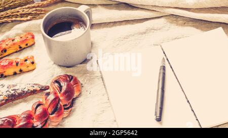 Breads And Toast For Breakfast With Notebook On White Bed Sheet 