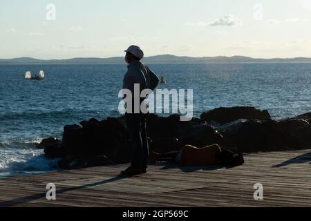 Salvador, Bahia, Brazil - June 17, 2021: Silhouette of a person enjoying the sea from Porto da Barra in Salvador, Bahia. Stock Photo