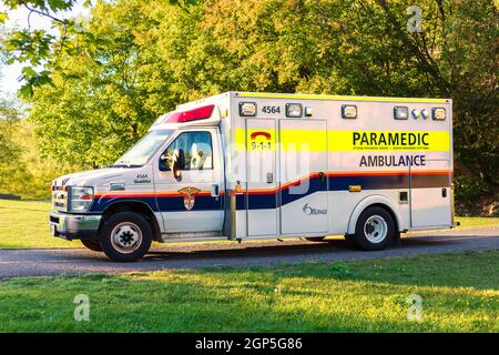 Ottawa, Canada - September 19, 2021: Ambulance parked in park, paramedic on call in public place. Stock Photo