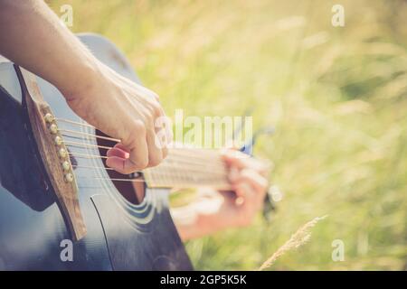 Close up of western guitar played outdoors at a river, summertime Stock Photo