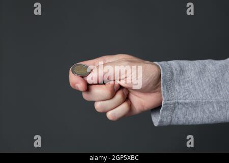 Hand ready to flip coin. Heads or tails game Stock Photo