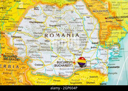 Romania national flag pinned on Europe map. Macro Close up picture of country on a colorful and Blurry World Map Globe with focus to capital Bucharest Stock Photo