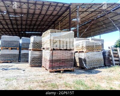 Tiles piled in pallets. Warehouse paving slabs in the factory for its production Stock Photo