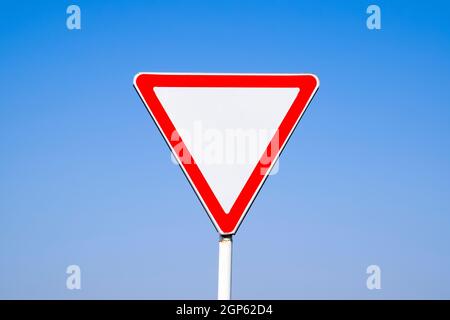 Road signs, give way. Sign on a blue background. Stock Photo