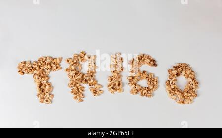 Inflated wheat seeds over a white surface grouped forming letter Stock Photo