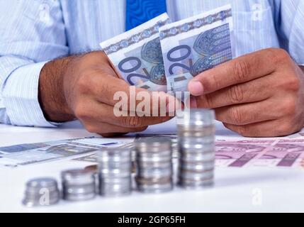 Man handling money and coins group of focus in the foreground Stock Photo