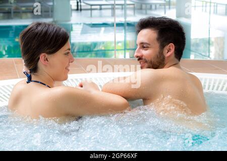 Close up portrait of attractive couple relaxing together in spa jacuzzi. Stock Photo