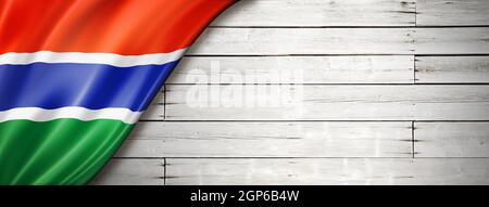 Gambia flag on old white wall. Horizontal panoramic banner. Stock Photo