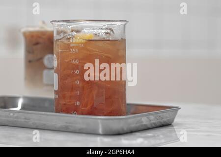 Beverage drinks come in a beaker. Cocktail served in a laboratory beaker at a science-themed bar. Chemistry bar Beaker Cocktail Glass Set Stock Photo