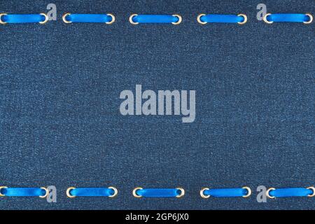 Fashionable beautiful background, blue satin ribbon inserted in denim fabric, with space for your creativity Stock Photo