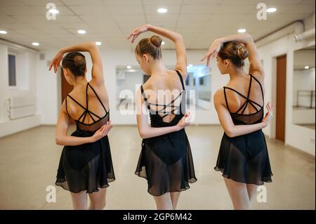 Three young ballerinas, teens rehearsing in class. Ballet school, female dancers on choreography lesson, girls practicing grace dance Stock Photo