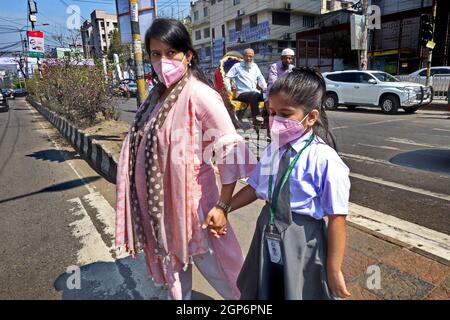 A mother and daughter during lockdown crossing the road. The country has had several lockdowns to contain the spread of the Coronavirus. Dhaka, Bangladesh. Stock Photo