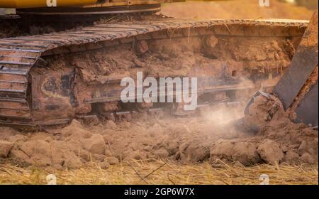 Backhoe working by digging soil at construction site. Bucket teeth of backhoe digging soil. Crawler excavator digging on soil. Excavating machine. Ear Stock Photo