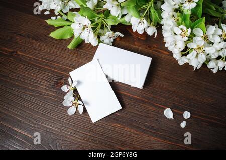Blank white business cards and flowers on wooden background. Branding ID template. Stock Photo