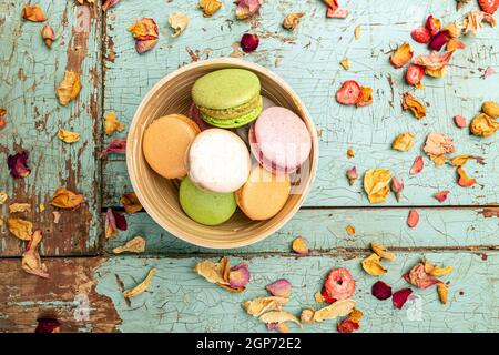 Cake macaron or macaroon on grungy turquoise background from above, colorful almond cookies Stock Photo